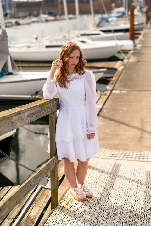 Konfirmand i hvid kjole ved havnen