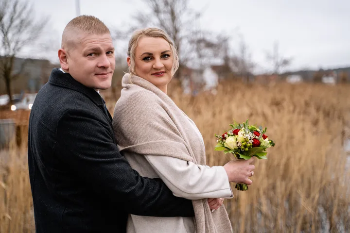 Portræt af brudepar med buket en vinterdag